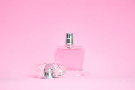 elegant perfume bottle with open lid on pink pastel backgroundの写真素材