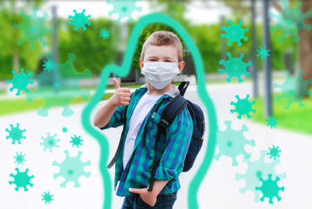 Schoolboy in a protective mask on the street on the way to school. Protective shell, viruses fly around. Back to school. Shows likeの写真素材