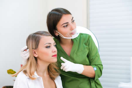 Young woman gets makeup. Lip tattoo in a beauty salon.