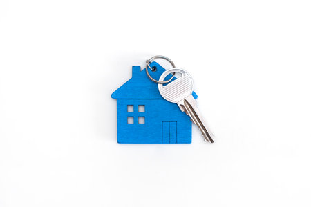 Blue mini house figure with keys on isolated white backgroundの写真素材