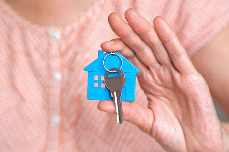 figure of a blue mini house with the keys are in the hand of a personの写真素材