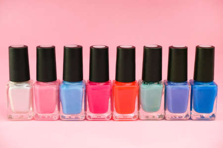 multicolored nail polishes on a pink background. Manicure conceptの写真素材