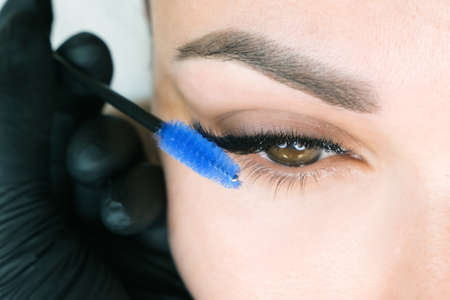 Eyelash extension procedure. Woman eye with long eyelashes. Close upの写真素材