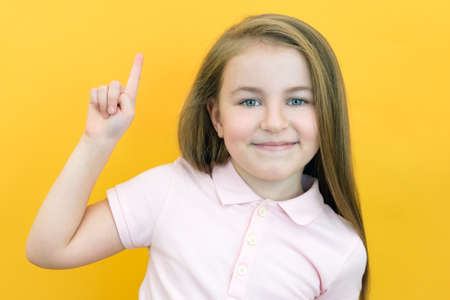 Wow, look, advertise here! Portrait of an astonished cute girl pointing at an empty space in the...