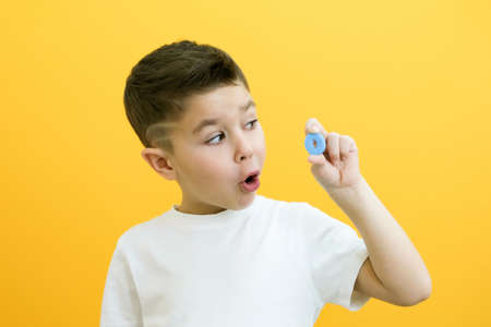 speech therapy. Toddler boy says the letter O. Classes with a speech therapist. boy on isolated yellow backgroundの写真素材