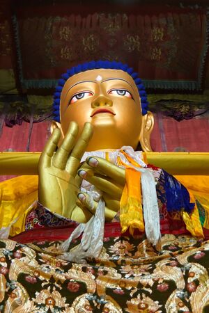 A golden image of Buddha on a tibetan templeの写真素材