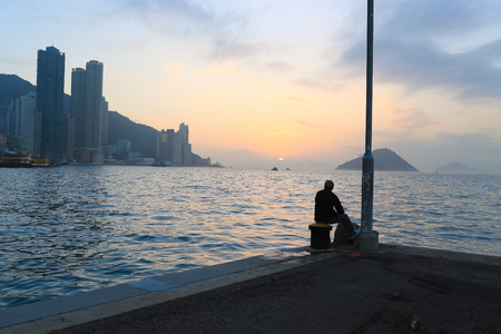 Man watching the far away sunsetの写真素材