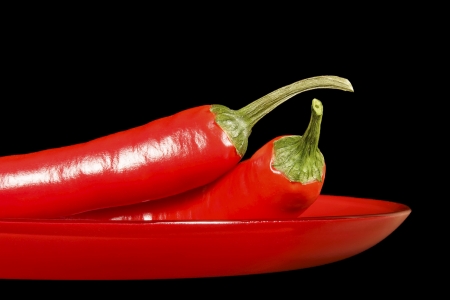Chile pepper pods on a red glass dish の写真素材