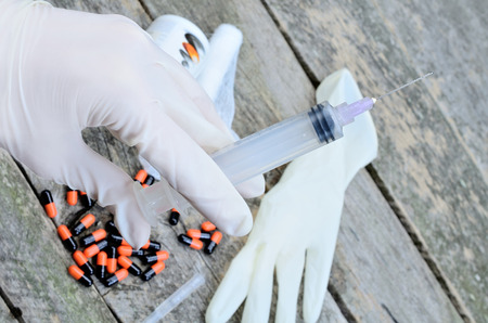 hand hold syringe on wooden tableの写真素材