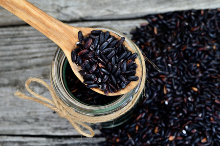 black rice on wooden tableの写真素材