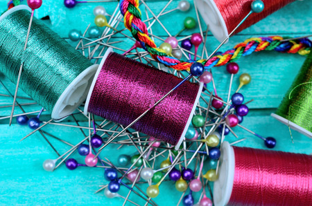 sewing with needle on blue wooden table