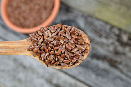 flax seed in wooden spoon on tableの写真素材