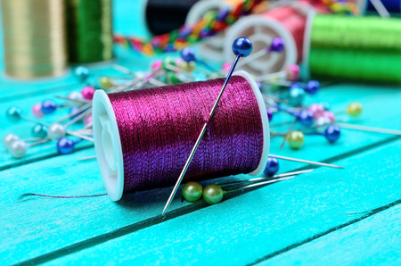 purple sewing thread on blue wooden table