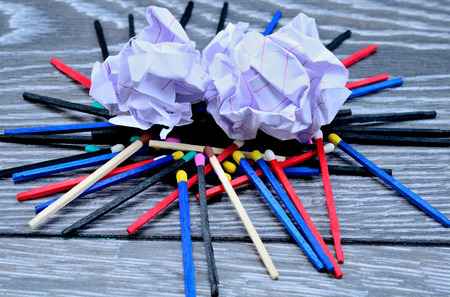 crumpled sheet with matches on gray wooden table