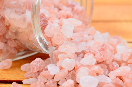 pink salt on brown wooden tableの写真素材