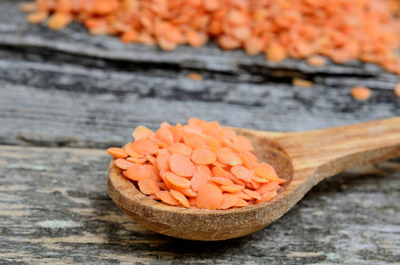 red lentil in spoon on wooden tableの写真素材