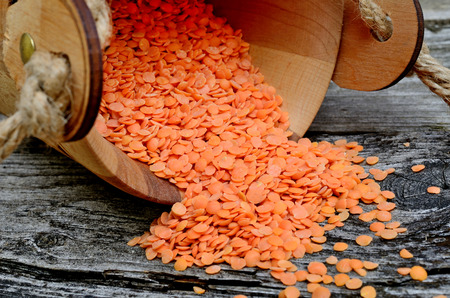 red lentil in bucket flow on wooden tableの写真素材