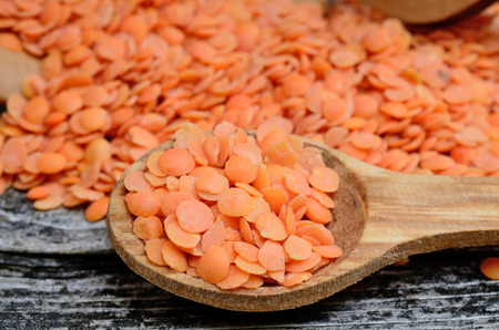 red lentil in spoon on wooden tableの写真素材