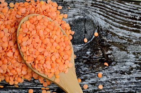 red lentil in spoon on wooden tableの写真素材
