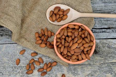 almond on wooden table with bowl and spoonの写真素材