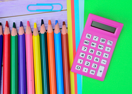 calculator and supplies for school on purple wooden tableの写真素材