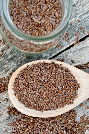 linseed in wooden spoon on wooden tableの写真素材
