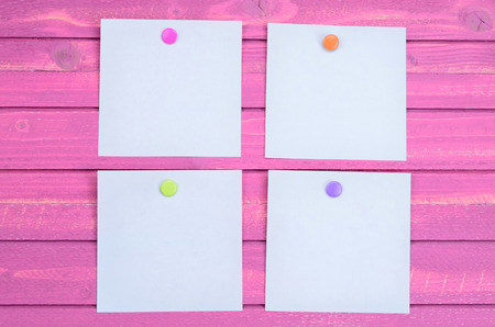 note with color push pin on pink wooden tableの写真素材