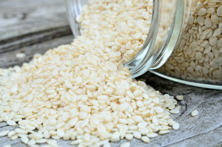 white sesame in bowl flow on wooden tableの写真素材
