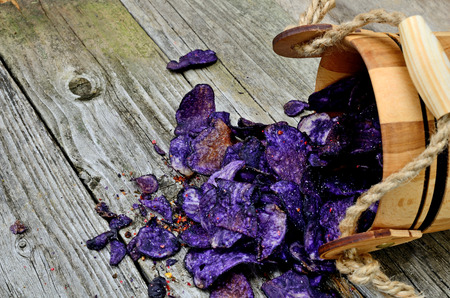 potato chips in bucket flow on wooden tableの写真素材