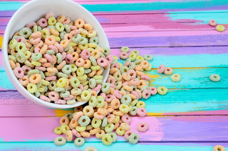 colored cereal in bowl on multicolored wooden table