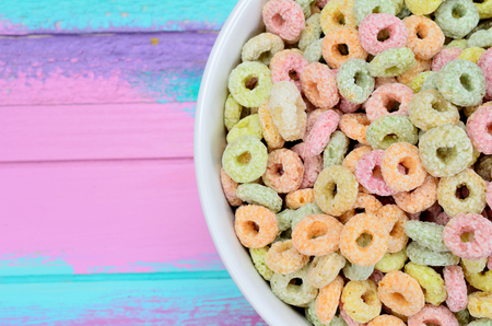 colored cereal in bowl on multicolored wooden tableの写真素材