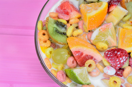 cereal with fruit in bowl on pink wooden table
