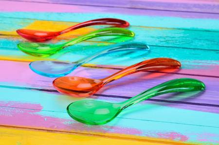 color spoon on multicolored wooden tableの写真素材