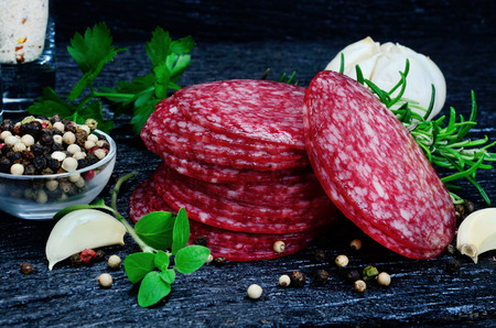 slices of salami on black wooden tableの写真素材