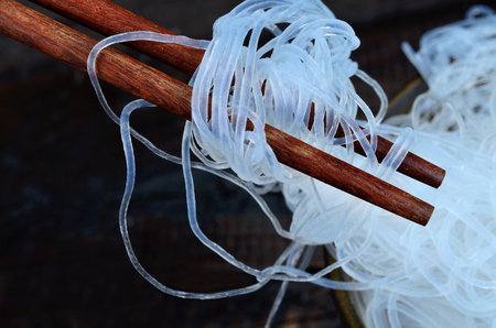 chinese noodle in pot on black wooden tableの写真素材