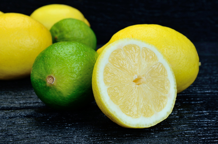 lemon and lime on black wooden tableの写真素材