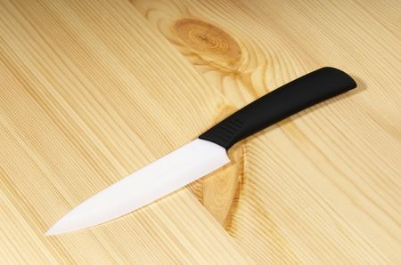 White ceramic knife on wood backgroundの写真素材