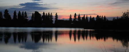 sun over the horizon of lake forestの写真素材