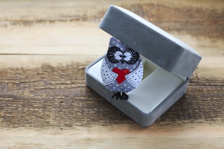 Handmade gray owl in box. Close up owl on wooden backgroundの写真素材