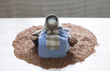 Doll on a heap of buckwheatの写真素材