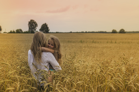 Mother and her daughter hugging in fieldの写真素材