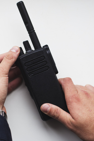 Mans hands holding black portable walkie talkieの写真素材