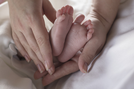 Feet of newborn baby in mother hands