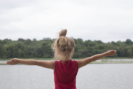 Little girl opened her arms wide, outdoors
