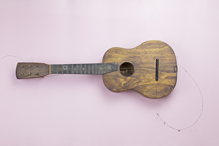 Old wooden guitar with torn metal stringsの写真素材
