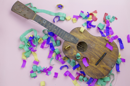 Old wooden guitar with torn strings in multi-colored confettiの写真素材