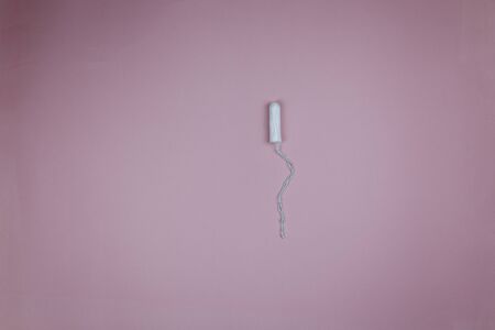 Female white tampon during menstruation on a dirty pink backgroundの写真素材