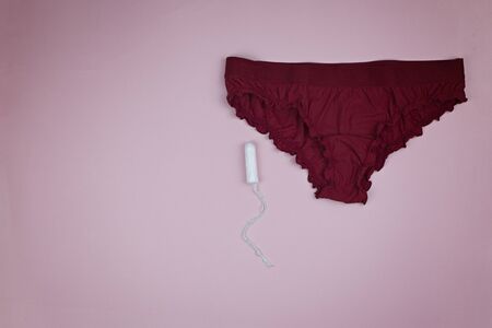 White cotton swab and womens underwear on a pink backgroundの写真素材