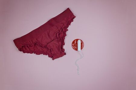 Red panties with a tampon on a pink backgroundの写真素材