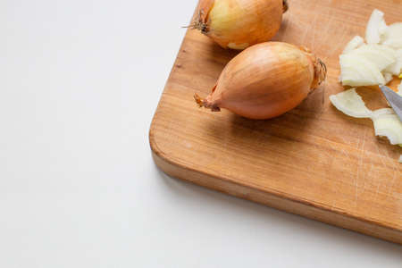 Chopped and whole onions on a boardの写真素材